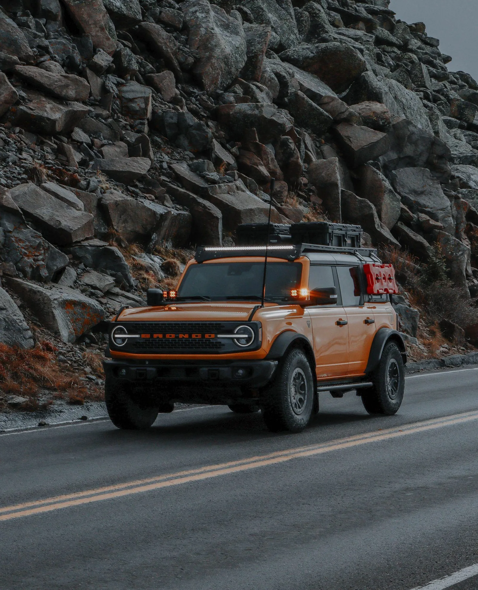 Orange Ford Bronco on a mountain road